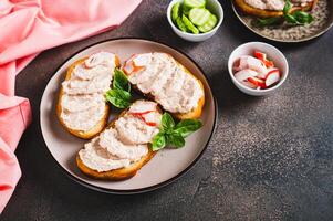 Delicious sandwiches with crab meat and cucumber pate on a plate on the table photo