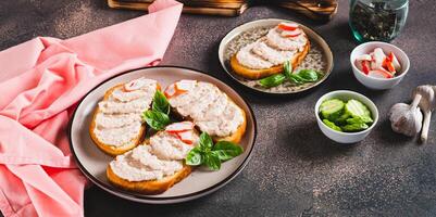 Crab stick and cucumber pate on toast on a plate on the table web banner photo