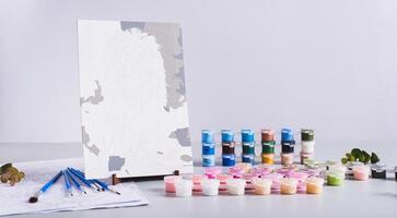 Acrylic paints, brushes and canvas for painting by numbers on the table web banner photo