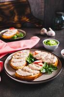 Crab stick and cucumber pate on toast on a plate on the table vertical view photo