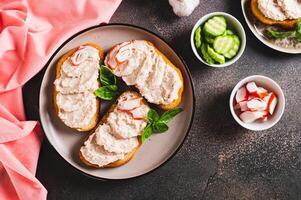 Crab stick and cucumber pate on toast on a plate on the table top view photo