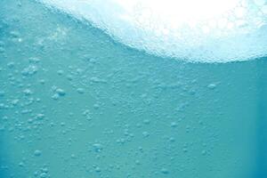 Close-up of clear blue water with bubbles, isolated on a white background. Perfect for water-related designs and ads photo
