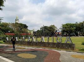 Central Java, Indonesia - November 21th 2023, a man is jogging in Pancasila Square, Salatiga City. This central public square is a popular gathering spot for locals and tourists photo