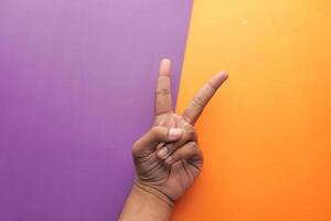 A Peace Sign Gesture Set Against a Vibrant and Colorful Background for Visual Impact photo