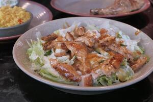 A mouthwatering Grilled Chicken Salad featuring Fresh Vegetables and a delectable Dressing photo