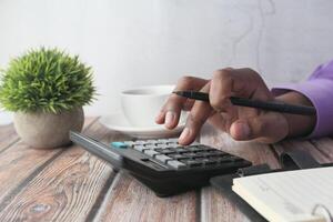 Business calculation conducted while enjoying coffee at a wooden table workspace photo