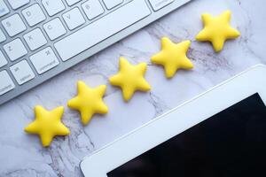 Vibrant yellow stars arranged on a desk with a keyboard and tablet, inspiring workspace photo