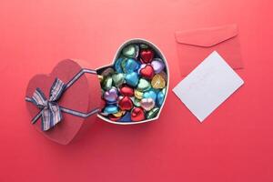 A HeartShaped Box Filled with a Variety of Colorful Chocolates Accompanied by a Note photo