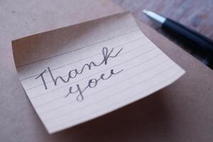 A beautifully crafted handwritten thank you note displayed on a stylish background photo