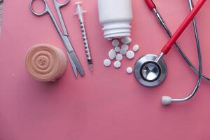 Medical Tools and Medications Displayed Against a Soft Pink Background for Visual Appeal photo