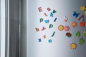 A vibrant assortment of Colorful Magnetic Letters and Shapes displayed on a Refrigerator Door photo