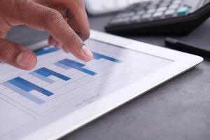 Performing a detailed analysis of data trends on a digital tablet while utilizing a calculator photo