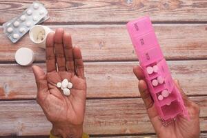 Effectively Organizing Medication Utilizing a Pillbox and Holding Tablets in Hands for Care photo