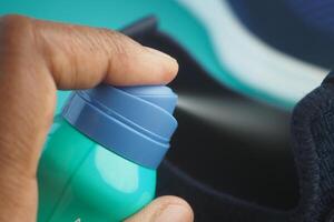 spraying deodorant on sweaty shoes. photo
