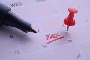 Dont forget to mark important tax deadlines on your calendar with a pushpin and a marker photo