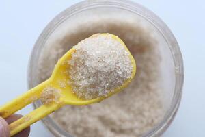 A Spoonful of Granulated Salt Carefully Mixed in a Container for Your Culinary Needs photo