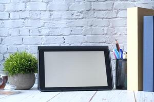 A modern desk setup with a mirror and neatly arranged stationery on a wooden table photo