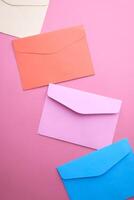 Vibrant and Colorful Envelopes on a Soft Pink Background for Innovative and Creative Design photo