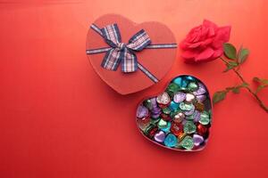 A HeartShaped Gift Box filled with Colorful Candies and a Beautiful Rose Inside photo