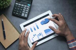 Hands Utilizing a Tablet Device to Analyze Data and Financial Charts in a Structured Manner photo