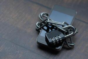 Ensuring Security and Privacy with a Mobile Phone Visualizing a Device Enclosed by Lock and Chains photo