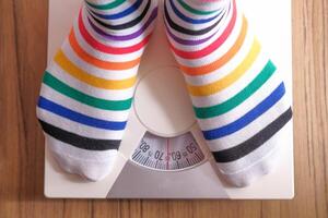 A collection of Colorful Socks displayed artistically on a Bathroom Scale for measurement photo