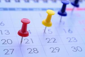 Bright and Colorful Push Pins on Calendar Dates for Enhanced Organization and Efficient Scheduling photo