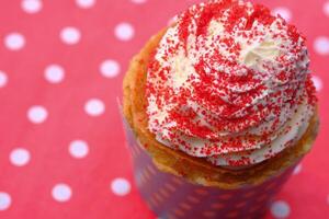 Enjoy a delightful cupcake topped with whipped cream and bright red sprinkles for any occasion photo