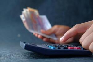 Carefully Calculating Finances with the Use of Cash and a Calculator for Accurate Results photo