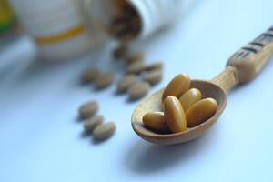 A Spoonful of Healthy Supplements Surrounded by Various Pills and Bottles in the Background photo