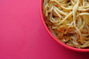 A bowl filled with delicious noodles presented beautifully on a vibrant and bright background photo
