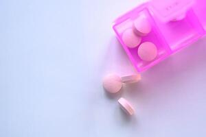 A colorful pill organizer showcasing various tablets against a soft, subtle background photo