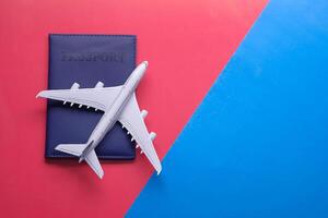 Essential Travel Items An Airplane Model and a Passport Displayed on a Bright, Colorful Background photo