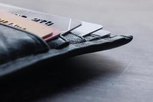 A detailed closeup image showcases a wallet abundantly filled with numerous credit cards inside it photo
