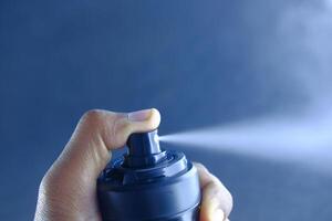 A person is holding a spray bottle and is about to trigger the mist release feature photo