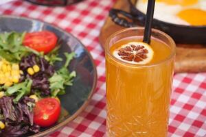 A Refreshing and Invigorating Drink Accompanied by Salad and Eggs on a Checkered Tabletop photo