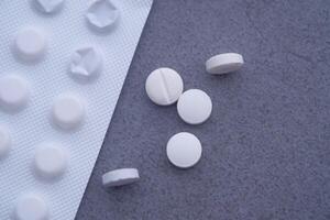 A Diverse Selection of White Tablets Arranged Neatly on a Grey Surface Background photo