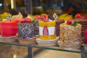 A Delicious Assortment of Mini Cakes Beautifully Displayed in a Bakery Case Today photo