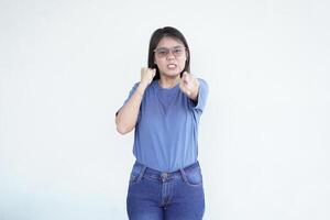 Beautiful Asian woman displays an angry gesture, pointing directly at the camera against a clean white background photo