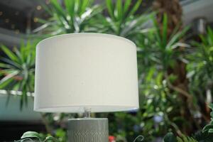 A Stylish Modern Table Lamp Set in a Lush Green Indoor Living Environment for Brightness photo