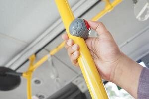 hand pressing Bus bell switch for stop inside the public bus photo