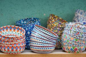 A beautiful array of colorful handpainted ceramic bowls elegantly displayed for sale photo