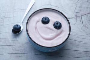 A Delightfully Delicious Yogurt Bowl Topped with Fresh Blueberries and a Cheerful Smiley Face photo