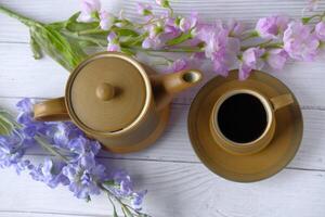 A Beautiful Tea Set Adorned with Colorful Flowers Resting on a Charming Wooden Table photo