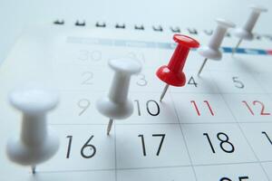 A detailed CloseUp of a Calendar Featuring Push Pins that Highlight Important Dates and Events photo