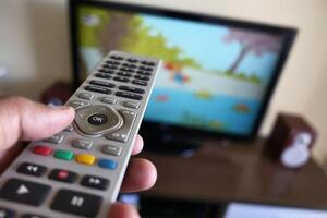 Scene showing a family engaging in remote control usage while watching television together photo