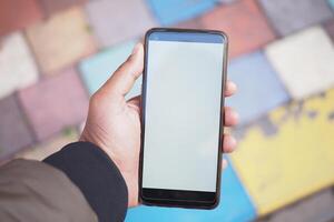 A smartphone in hand rests on a colorful paved surface, creating an inviting scene photo