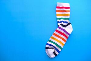 A colorful rainbow sock on a bright blue background creates an eyecatching visual photo