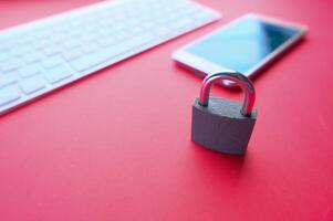 Cyber Security is shown by a padlock on a smartphone with a red background, symbolizing safety photo