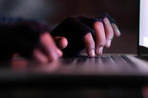 hacker hand stealing data from laptop top down photo